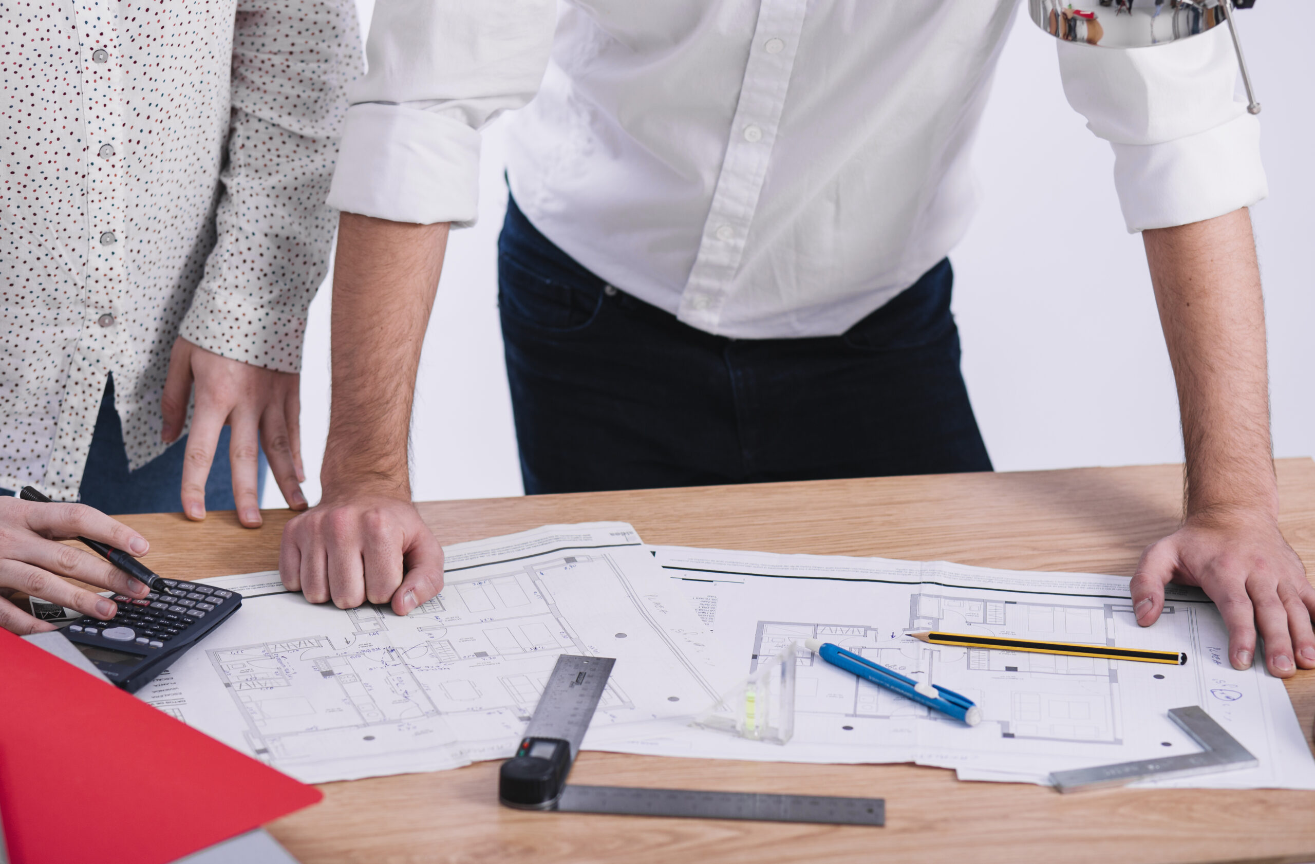 Personas con planos sobre la mesa.